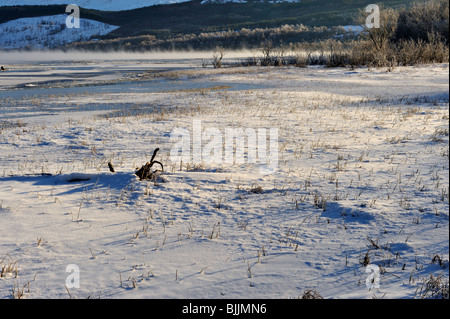 Frost-Rauch steigt aus einem schmalen Streifen des Oberflächenwassers in einem zugefrorenen See am Loch Tay, Perthshire, Schottland Stockfoto