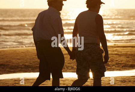 Älteres Ehepaar zu Fuß am Strand Stockfoto