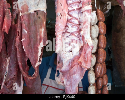 transluzente hängende Streifen von rohem Fleisch & Würstchen an einem Metzger Stand auf Straße außen Benito Juarez Markt Oaxaca Mexico Stockfoto