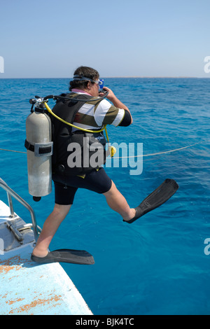 Taucher, die einen großen Schritt zu tun, ins Wasser geben Stockfoto