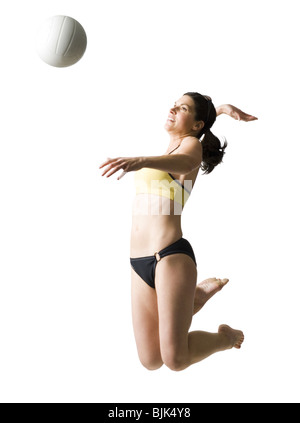 Frau im Bikini springen und Volleyball spielen Stockfoto