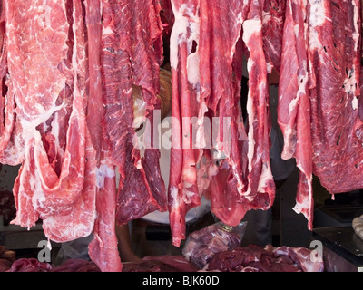 zart farbige Streifen von rohem Fleisch hängen in einer Metzgerei auf der Straße vor Benito Juarez Markt Oaxaca Mexico Stockfoto