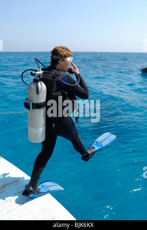 Taucher, die einen großen Schritt zu tun, ins Wasser geben Stockfoto