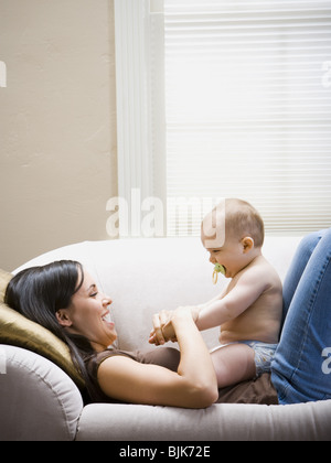 Frau liegend auf Sofa mit baby Stockfoto