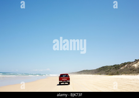 Eine rote Allradfahrzeug auf dem Sand Highway auf 75 Mile Beach auf Fraser Island, Queensland Stockfoto