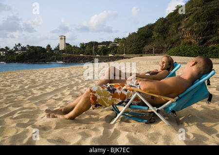 Mann und Frau liegen in Stühle am Strand Stockfoto