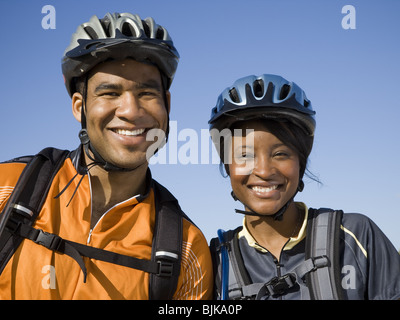 Mann und Frau mit Fahrräder und Helme im freien Lächeln Stockfoto