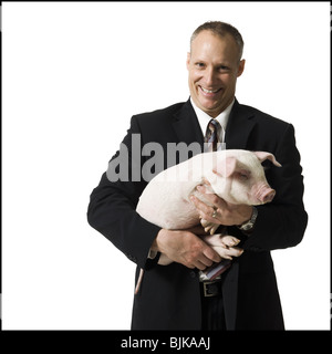 Geschäftsmann Holding Aktenkoffer und Ferkel Stockfoto