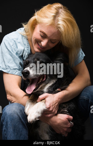 Porträt einer Frau mit Blick auf schwarze Hund lächelnd Stockfoto