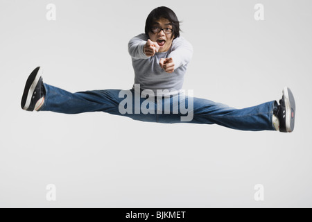 Mann mit Brille springen und zeigt Stockfoto