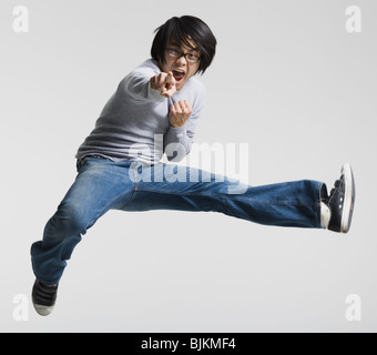 Mann mit Brille springen und zeigt Stockfoto