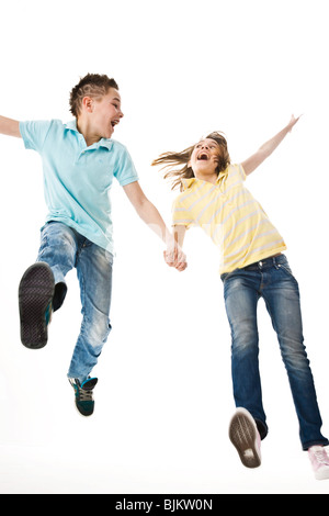 Ein Junge und ein Mädchen zusammen in die Luft springen Stockfoto