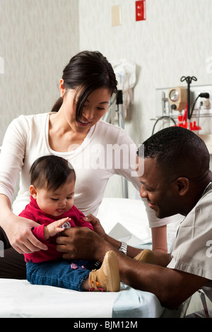 Mutter und Kind bei der Prüfung der Zimmer mit Arzt Stockfoto