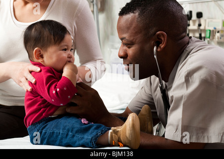 Mutter und Kind bei der Prüfung der Zimmer mit Arzt Stockfoto