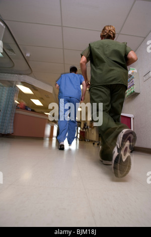 Arzt und Krankenschwester von hinten im Flur laufen Stockfoto