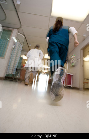 Arzt und Krankenschwester Rauschen durch Korridor Stockfoto