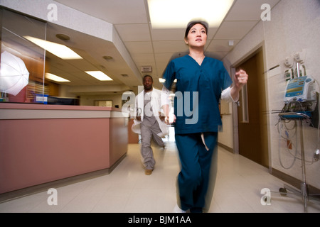 Arzt und Krankenschwester Rauschen durch Korridor Stockfoto