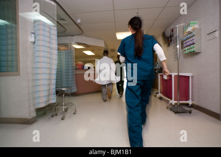 Arzt und Krankenschwester Rauschen durch Korridor Stockfoto