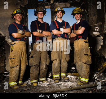 Gruppenbild der Feuerwehrleute in verbrannten Zimmer Stockfoto