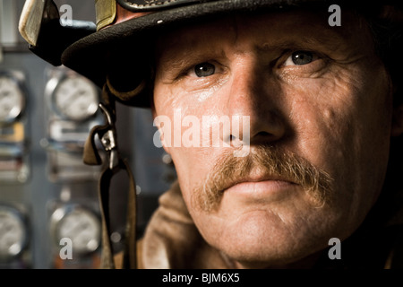 Porträt eines Feuerwehrmannes vor Systemsteuerung Stockfoto
