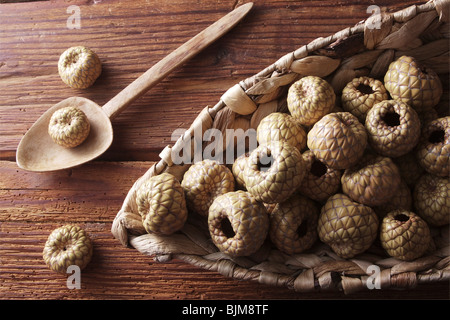 Salak oder Snake Fruit (Salacca Zalacca) in einem Weidenkorb auf einem rustikalen hölzernen Hintergrund Stockfoto