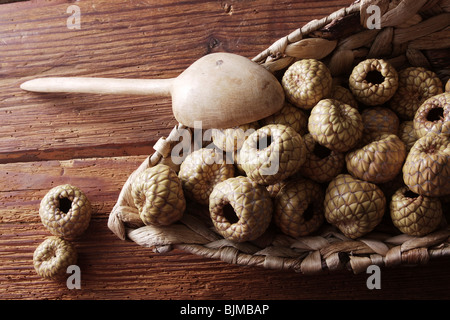 Salak oder Snake Fruit (Salacca Zalacca) in einem Weidenkorb auf einem rustikalen hölzernen Hintergrund Stockfoto