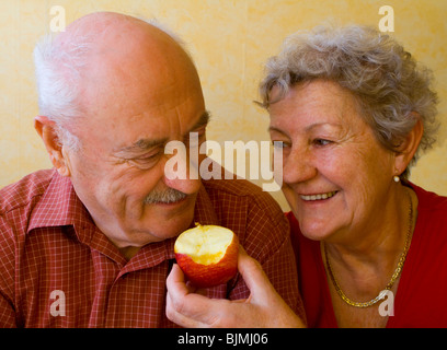 Frau, Fütterung einem Mann einen Apfel, Rentner Stockfoto