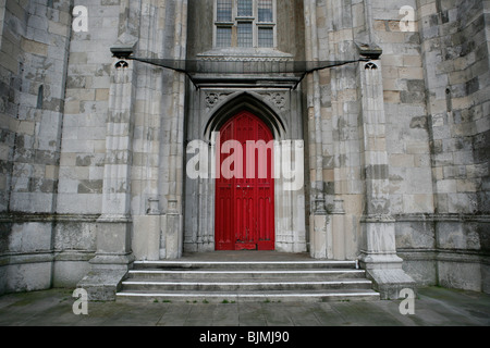 Vor dem Eingang der St. Peters-Kirche mit einer roten Tür in Brighton, England. Stockfoto