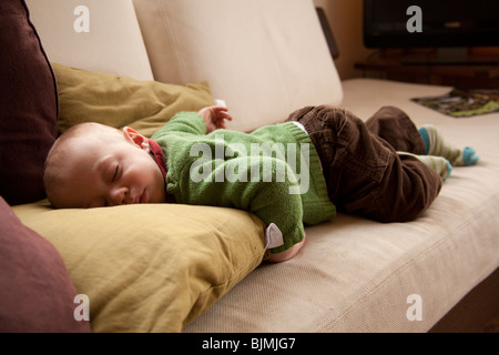 Baby Boy (elf Monate alt) schläft auf dem Sofa Hampshire England. Stockfoto