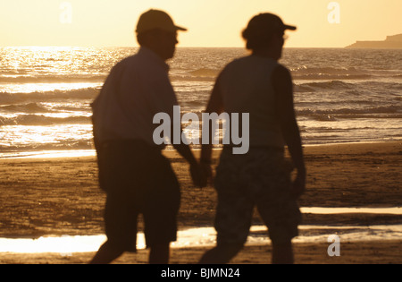 Älteres Ehepaar zu Fuß am Strand Stockfoto