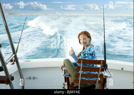 Fisher Frau Großwild auf Boot Stuhl Schild glücklich Stockfoto