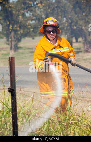 CFA Feuerwehrleute bekämpfen Brandfall am Straßenrand in der Nähe von Shepperton, Victoria, Australien. Stockfoto