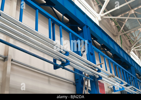 Fabrik Hitze Versorgungsnetz zwischen Verbrauchern funktioniert durch oberirdische Rohrleitungen an der Wand und Spalten. Stockfoto