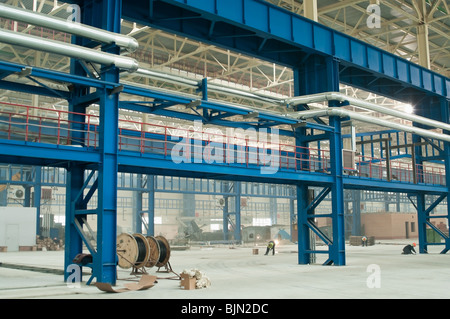 Fabrik Hitze Versorgungsnetz zwischen Verbrauchern funktioniert durch oberirdische Rohrleitungen an der Wand und Spalten. Stockfoto