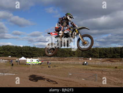 Motorradfahrer fliegt hoch in die Luft auf dem Motocross-Bike. Stockfoto