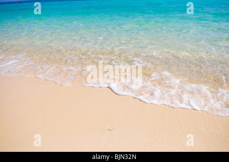 Tropischer Strand mit weißen Korallen Sand und ruhigem wave