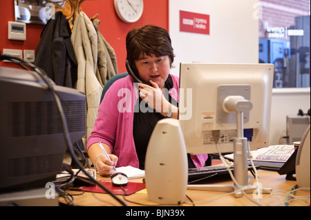 eine Journalistin am Telefon arbeiten in der BBC Radio Wales / Cymru Nachrichtenredaktion Büro und Atelier, Aberystwyth Wales UK Stockfoto