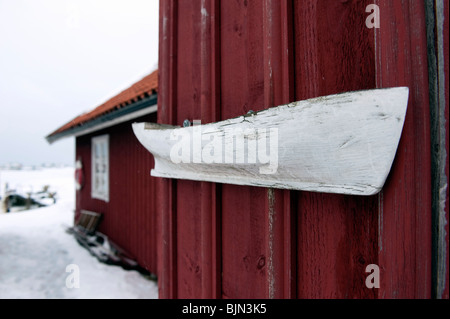 Kleinen alten Holzboot an Wand des roten Bootshaus in Fiskebackskil an Bohuslan Küste in Vastra Gotaland Schweden Stockfoto