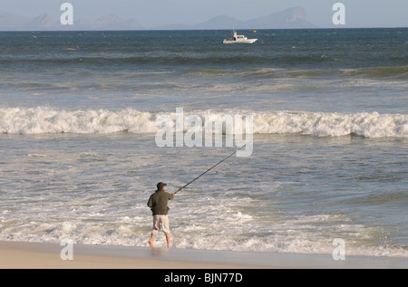 Mann Angeln vom Strand von Muizenberg in der western Cape-Südafrika Stockfoto