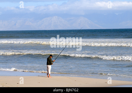 Mann Angeln vom Strand von Muizenberg in der western Cape-Südafrika Stockfoto