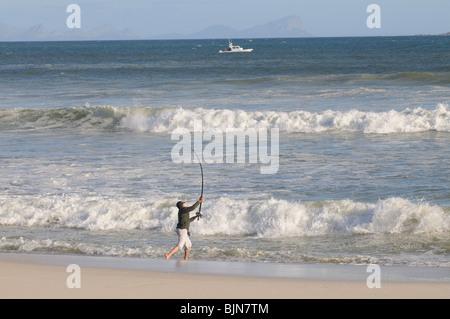 Mann Angeln vom Strand von Muizenberg in der western Cape-Südafrika Stockfoto