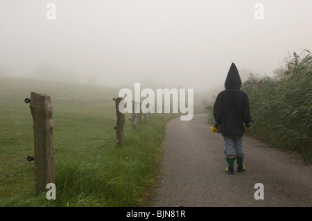 Silhouette eines Kindes zu Fuß im Morgennebel, Neuenkirchen, Deutschland Stockfoto