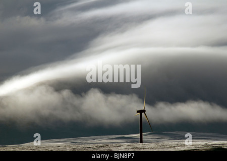 Windgenerator auf dem Schnee bedeckt Hügel in Caithness, Schottland, Vereinigtes Königreich.  Ein Nebel bedeckt Hügel hinter. Stockfoto