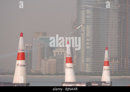 27.03.2010. Abu Dabi. Red Bull Air Race. Flugzeug fliegt zwischen Marker leuchten während des Rennens. Stockfoto