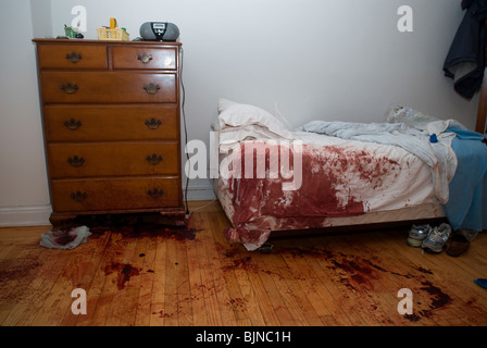 Blut befleckt Bett und Boden werden nach einem schrecklichen Unfall in einer Wohnung in New York gesehen. Stockfoto