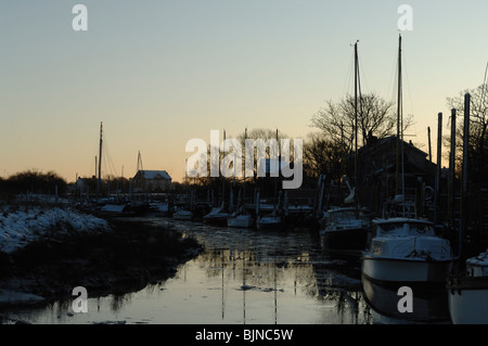 Yachten ankern bei Stegen am Skippool Creek im letzten Licht im Winter. Stockfoto