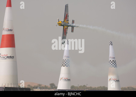 27.03.2010. Abu Dabi. Red Bull Air Race. Flugzeug fliegt zwischen Marker leuchten während des Rennens. Stockfoto