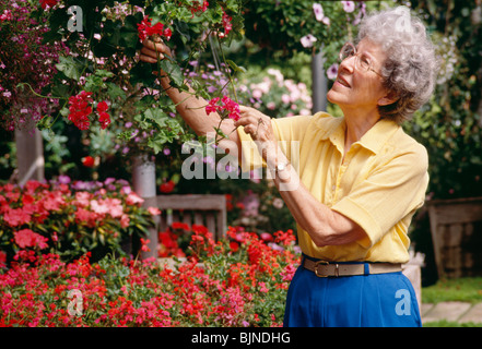 Ältere Frau in Blume Kindergarten Stockfoto