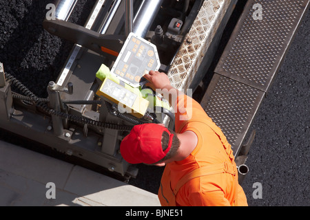 Mann arbeitet am Control Panel Asphalt Maschine Stockfoto