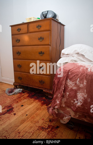 Blut befleckt Bett und Boden werden nach einem schrecklichen Unfall in einer Wohnung in New York gesehen. Stockfoto